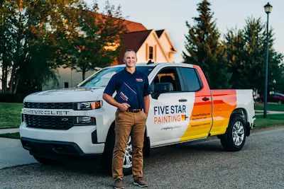 A Five Star Painting professional standing in front of a company truck.